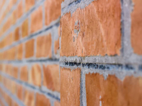 Brick wall seen at a low angle along its face, the view used to spot a bowed section