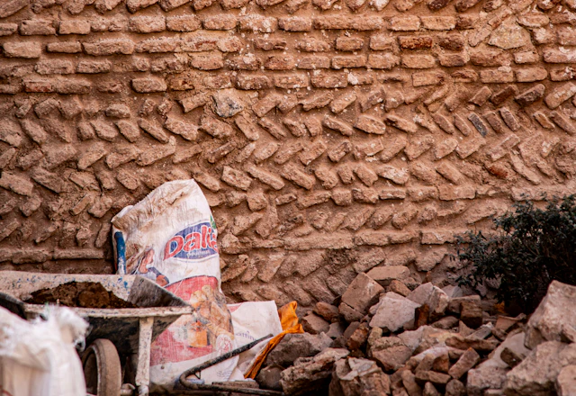 Brick wall with construction debris at its base during masonry removal