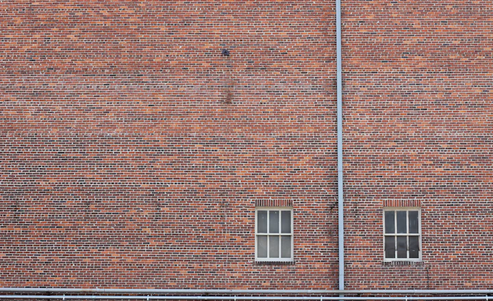 Two closed window openings in an old brick wall