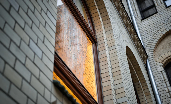 Close-up of a brick building around a large window opening