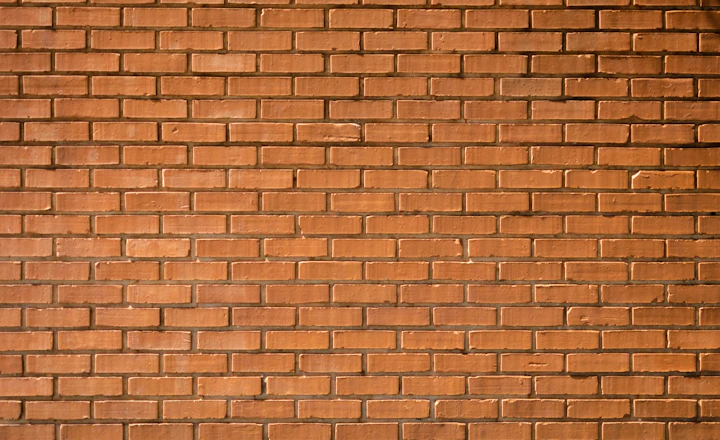 Close-up of a brown brick wall showing the mortar joints between courses