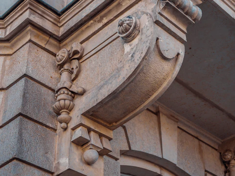Close view of an older building corner and cornice where units should sit in a straight line