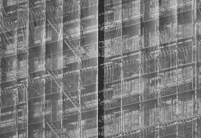 Building facade wrapped in scaffolding and safety netting