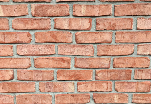 Red brick wall with clean, even mortar joints in daylight