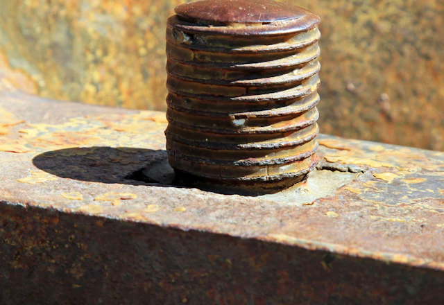 Close-up of a rusty bolt, like the corroded anchors found behind cracked terra cotta
