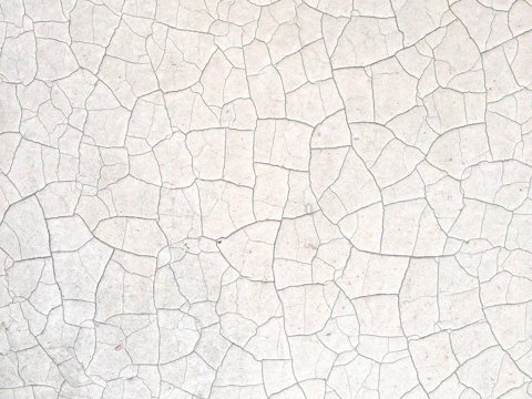 Close-up of a pale facade surface with cracks running across it