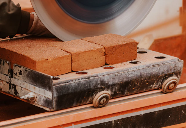 Mason cutting masonry with a power saw, a tool kept to bed joints and used with care on older brick