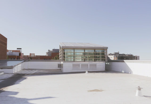 Flat building roof with its edge and neighboring buildings in view