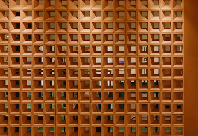 Wall of terracotta blocks with square hollow openings, showing how the units are made