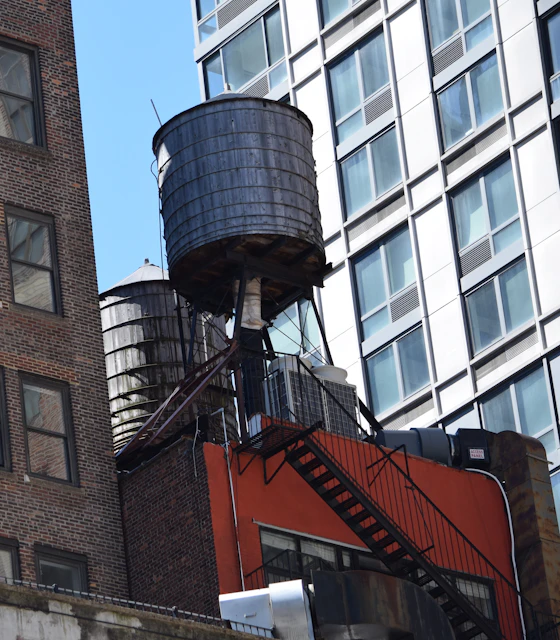 Water towers on city rooftops among apartment buildings