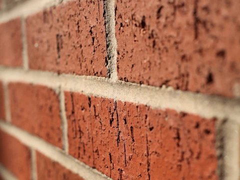 Brick wall with an open gap where mortar and brick have fallen out of the joint