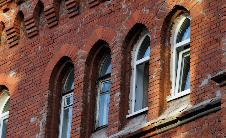 Old brick facade with arched windows and ornate decorative trim