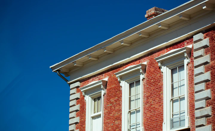 Top of a red and gray building under a blue sky