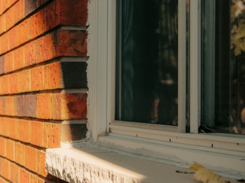 Window set into a brick wall, where a sagging lintel can pinch the frame and make the sash stick