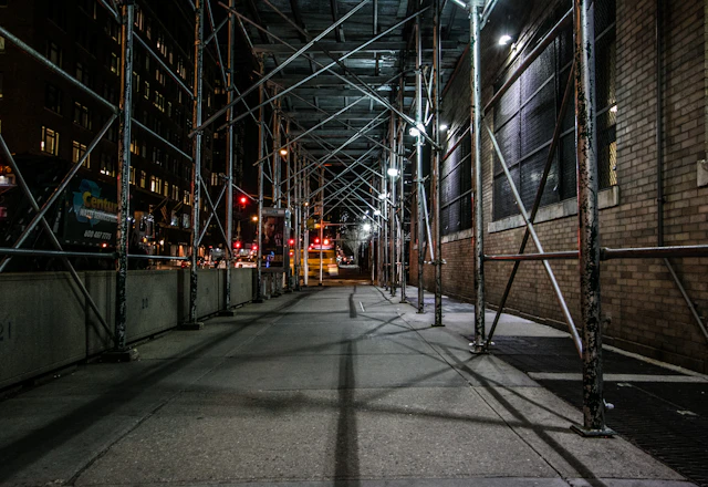 Scaffolding set up beside a brown brick building for facade repair access