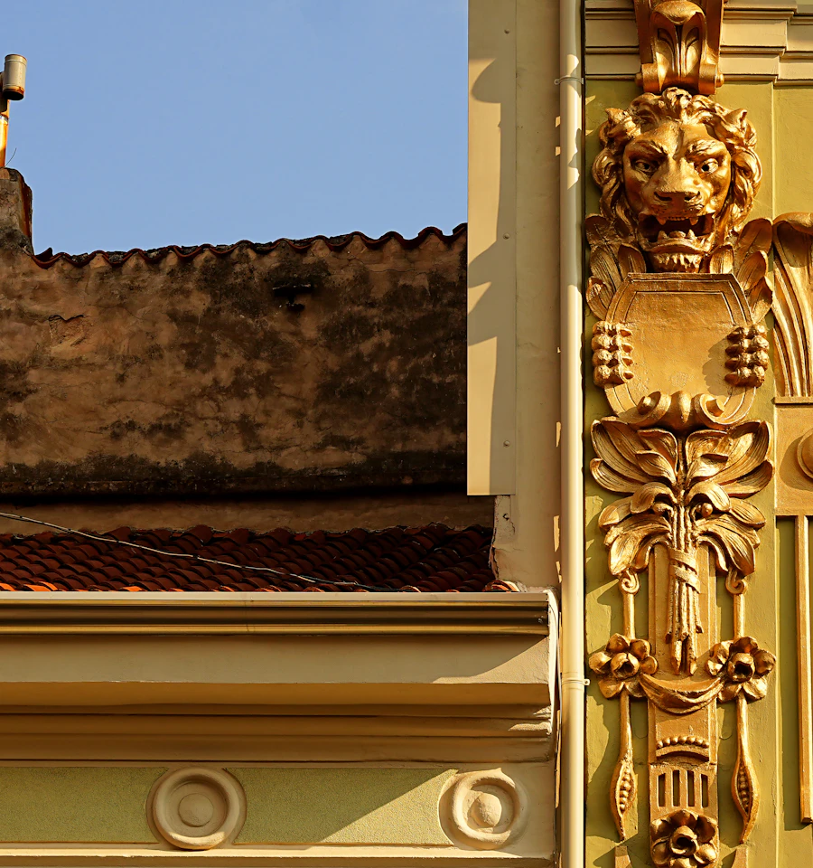 Ornate glazed terra cotta ornament around the windows of an older building facade